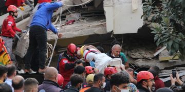 Rescuers and local volunteers carry a wounded victim on a stretcher from a collapsed building after a powerful earthquake struck Turkey's western coast and parts of Greece, in Izmir, on October 30, 2020. - A powerful earthquake hit Turkey and Greece on October 30, killing at least six people, levelling buildings and creating a sea surge that flooded streets near the Turkish resort city of Izmir. (Photo by - / IHLAS NEWS AGENCY / AFP) / Turkey OUT