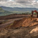 An excavator moves earth to a dump truck at a mining site of Venezuelan iron ore producer CVG Ferrominera Orinoco, on Bolivar Hill outside of Ciudad Piar, Venezuela, on Thursday, July 9, 2015. Photographer: Meridith Kohut/Bloomberg