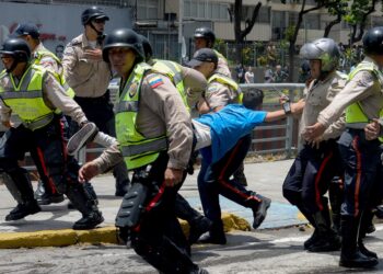 Police carry a demonstrator under arrest during a protest against President Nicolas Maduro's government in Caracas on April 4, 2017. 
Activists clashed with police in Venezuela Tuesday as the opposition mobilized against moves to tighten President Nicolas Maduro's grip on power. Protesters hurled stones at riot police who fired tear gas as they blocked the demonstrators from advancing through central Caracas, where pro-government activists were also planning to march. / AFP PHOTO / FEDERICO PARRA