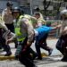 Police carry a demonstrator under arrest during a protest against President Nicolas Maduro's government in Caracas on April 4, 2017. 
Activists clashed with police in Venezuela Tuesday as the opposition mobilized against moves to tighten President Nicolas Maduro's grip on power. Protesters hurled stones at riot police who fired tear gas as they blocked the demonstrators from advancing through central Caracas, where pro-government activists were also planning to march. / AFP PHOTO / FEDERICO PARRA