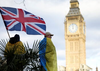 FILE PHOTO: A demonstrator holds a British flag during a protest against Russia's invasion of Ukraine, at Parliament Square in London, Britain, March 6, 2022. REUTERS/Henry Nicholls/File Photo