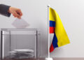 Glass ballot box and a small Colombia flag. 3d illustration