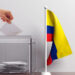 Glass ballot box and a small Colombia flag. 3d illustration